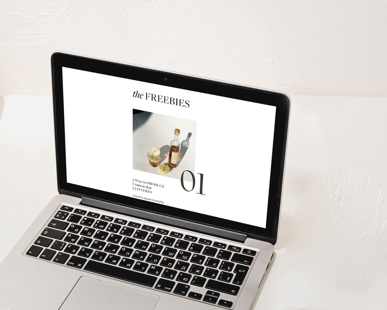 Laptop displaying a minimalist email welcome series template with a “Freebies” headline and styled content section on a clean white background.